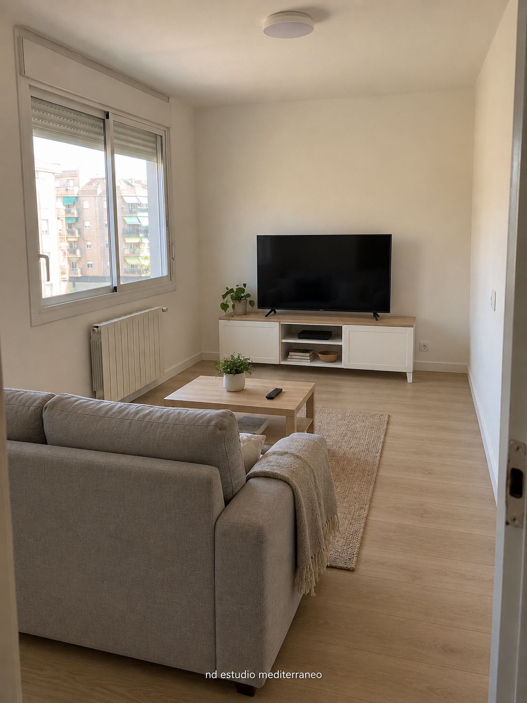 Salón reformado con sofá, mesa de centro y mueble de televisión suspendido